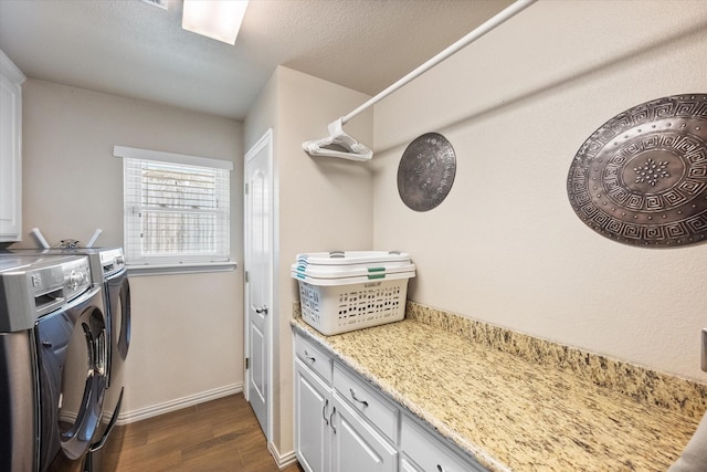 laundry area featuring a textured ceiling, dark wood-style flooring, baseboards, cabinet space, and washing machine and clothes dryer