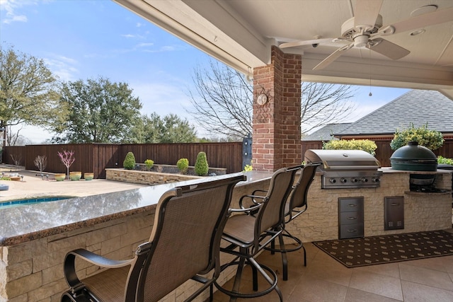 view of patio with outdoor wet bar, area for grilling, a grill, a ceiling fan, and fence