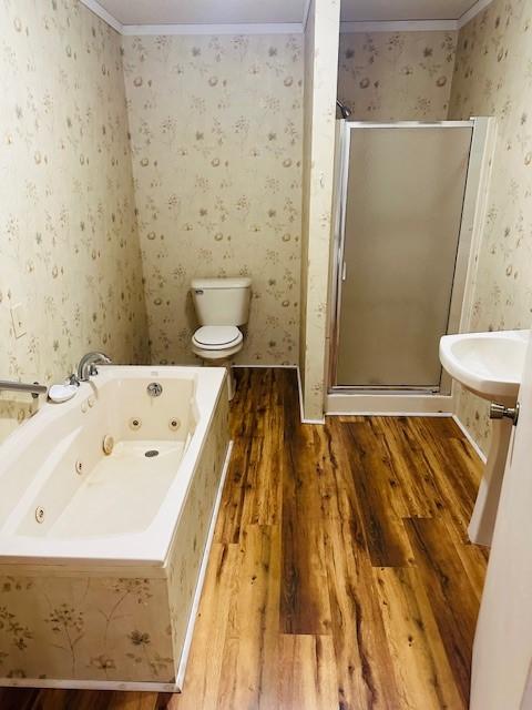 bathroom with wallpapered walls, wood finished floors, a whirlpool tub, crown molding, and a shower stall