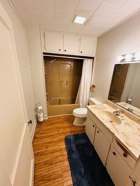 full bath featuring vanity, shower / bath combo with shower curtain, wood finished floors, and toilet