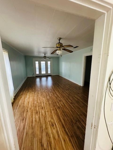 spare room with ceiling fan, baseboards, and wood finished floors