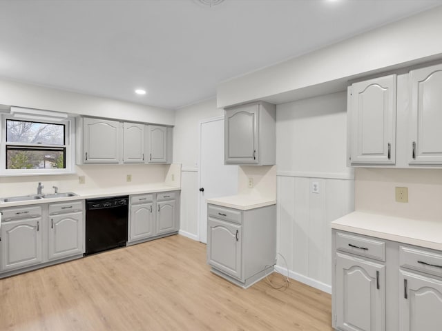 kitchen with dishwasher, light wood-style flooring, gray cabinets, light countertops, and a sink