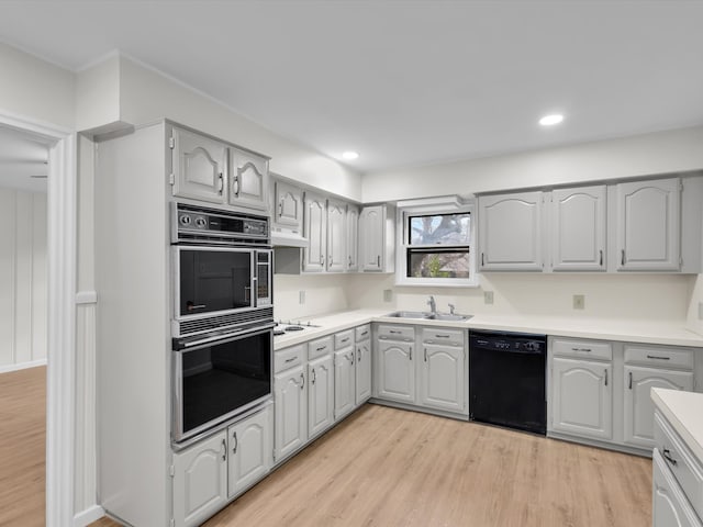 kitchen featuring light wood-style floors, light countertops, black appliances, a sink, and recessed lighting