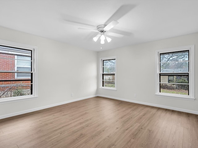 unfurnished room with a ceiling fan, baseboards, and wood finished floors