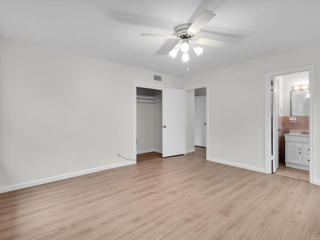 unfurnished bedroom with a sink, visible vents, baseboards, a closet, and light wood-type flooring