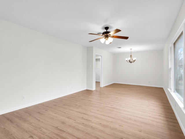 unfurnished room featuring light wood-type flooring, baseboards, and ceiling fan with notable chandelier