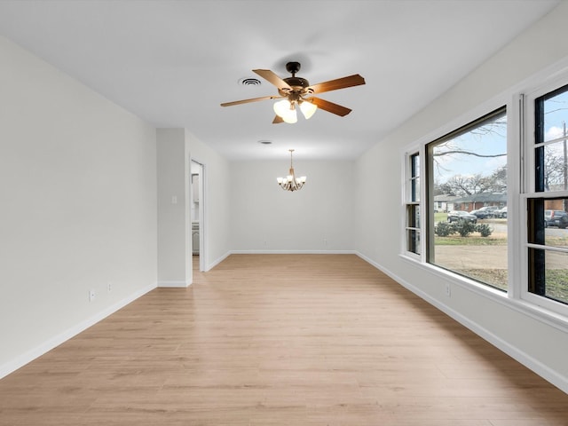 spare room with light wood-style floors, plenty of natural light, visible vents, and baseboards