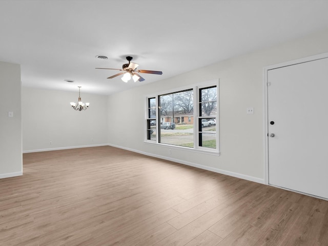 interior space with light wood-style floors, visible vents, baseboards, and ceiling fan with notable chandelier