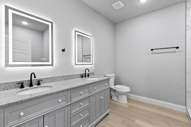 bathroom with visible vents, a sink, toilet, and wood finished floors