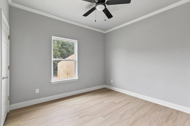 spare room with ornamental molding, light wood-type flooring, a ceiling fan, and baseboards