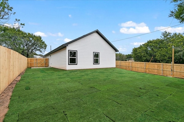 rear view of property with a fenced backyard and a yard