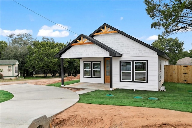 modern farmhouse with fence and a front lawn