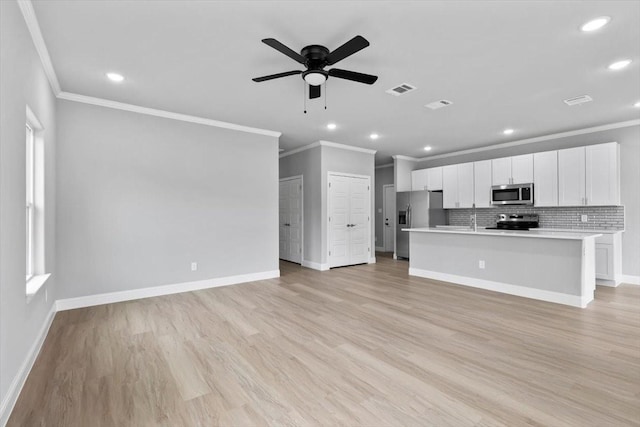 kitchen featuring visible vents, light countertops, appliances with stainless steel finishes, light wood-type flooring, and backsplash