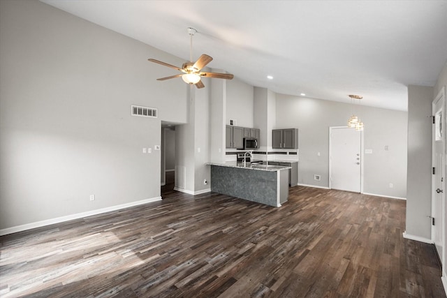 kitchen with visible vents, stainless steel microwave, gray cabinetry, dark wood-type flooring, and a sink