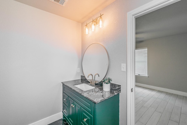 bathroom with wood finished floors, vanity, visible vents, and baseboards