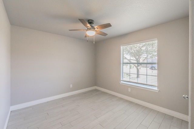 unfurnished room with light wood-type flooring, baseboards, and a ceiling fan