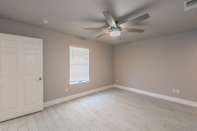 unfurnished room featuring ceiling fan, light wood-type flooring, visible vents, and baseboards