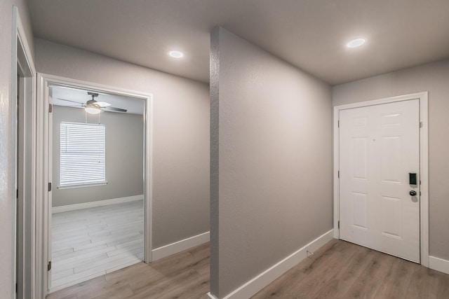 interior space featuring light wood-style floors, ceiling fan, and baseboards