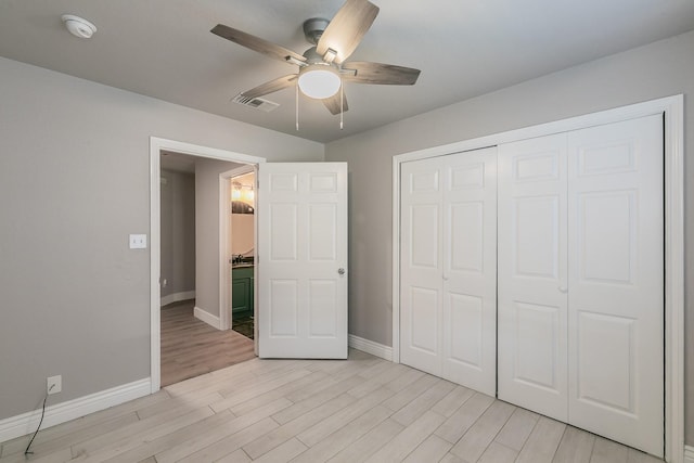 unfurnished bedroom featuring visible vents, baseboards, a ceiling fan, light wood-style flooring, and a closet