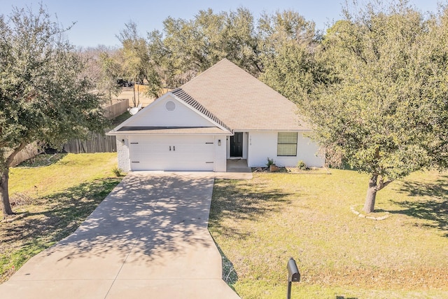 view of front facade with a front yard, concrete driveway, fence, and an attached garage