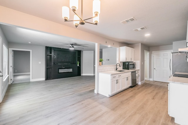 kitchen with stainless steel appliances, light countertops, visible vents, and a sink