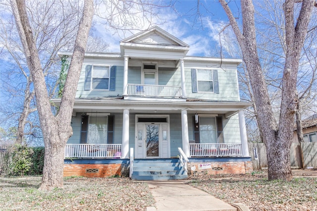 greek revival inspired property with a porch, a balcony, fence, and crawl space