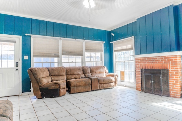 living room featuring crown molding, a fireplace, and tile patterned flooring