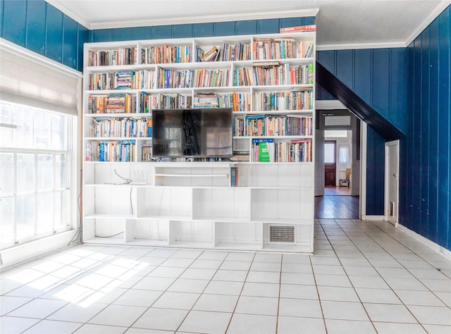 unfurnished living room featuring tile patterned floors, visible vents, built in features, and crown molding