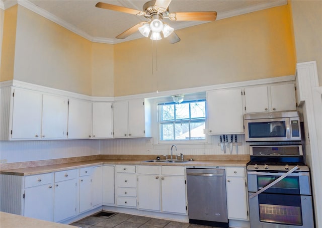 kitchen with ornamental molding, appliances with stainless steel finishes, light countertops, and a sink