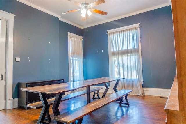 dining room featuring visible vents, a ceiling fan, wood finished floors, crown molding, and baseboards