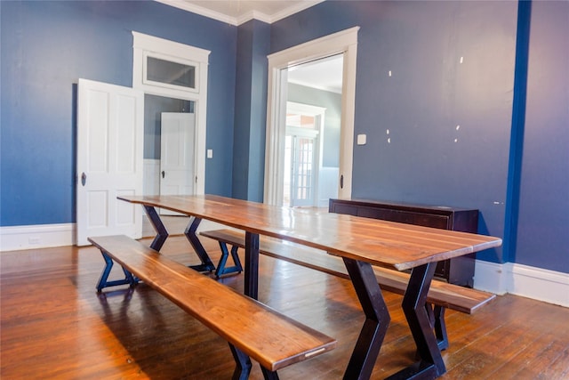 dining room with baseboards, wood-type flooring, and ornamental molding