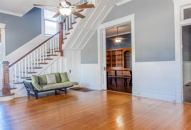 sitting room with stairs, wood finished floors, and a wainscoted wall