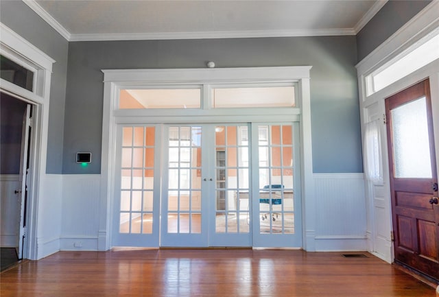 interior space with visible vents, wainscoting, french doors, and wood finished floors