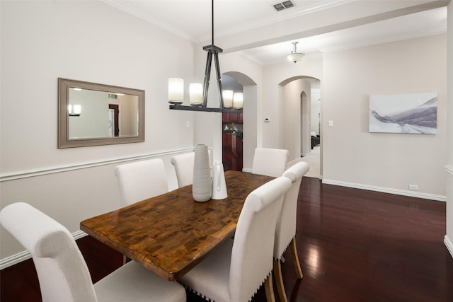 dining area featuring baseboards, visible vents, arched walkways, dark wood-style flooring, and crown molding