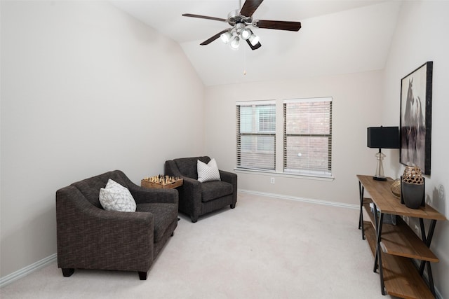 living area featuring lofted ceiling, baseboards, a ceiling fan, and light colored carpet