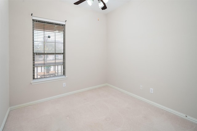 spare room with light carpet, ceiling fan, and baseboards