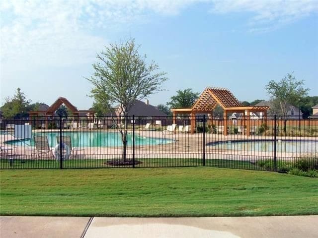 pool with fence and a lawn