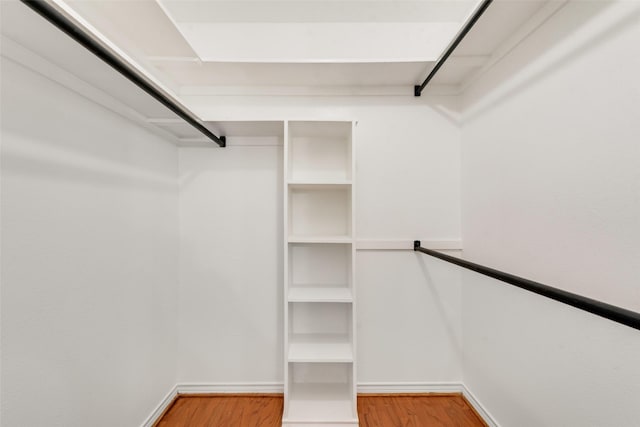 walk in closet with wood finished floors