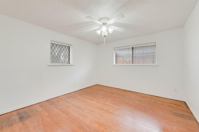 spare room featuring baseboards, a textured ceiling, a ceiling fan, and wood finished floors