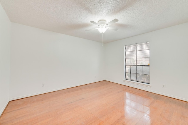 unfurnished room featuring ceiling fan, a textured ceiling, baseboards, and wood finished floors