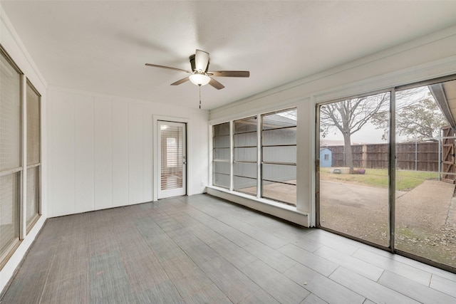 unfurnished sunroom with a ceiling fan