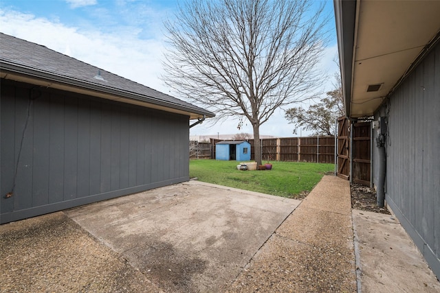 view of patio with an outbuilding, a storage shed, and a fenced backyard