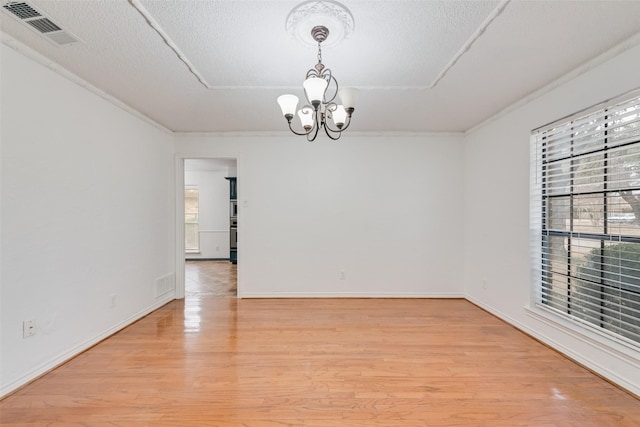 unfurnished room with a chandelier, visible vents, plenty of natural light, and light wood-style flooring