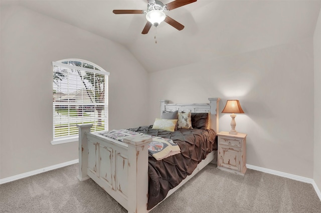 bedroom featuring light carpet, baseboards, vaulted ceiling, and a ceiling fan