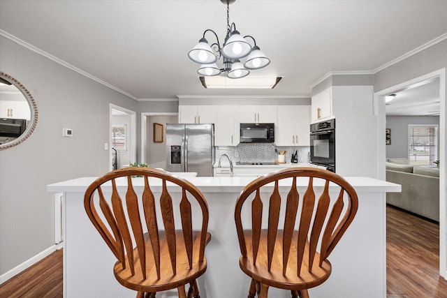 dining space with crown molding, a chandelier, dark wood finished floors, and baseboards