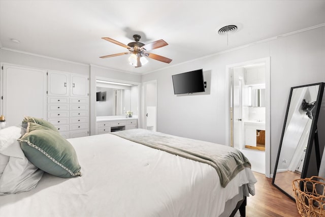 bedroom featuring a ceiling fan, light wood-type flooring, visible vents, and crown molding