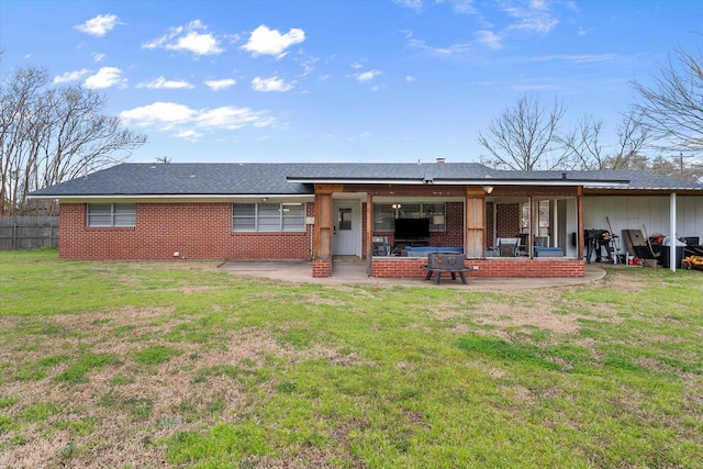 back of house featuring a yard, fence, brick siding, and a patio