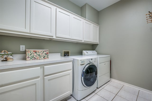 clothes washing area with light tile patterned flooring, cabinet space, baseboards, and separate washer and dryer