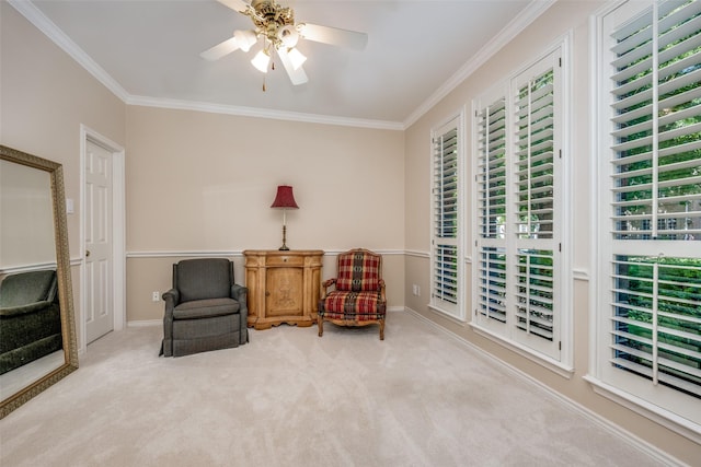 sitting room with ornamental molding, carpet flooring, a ceiling fan, and baseboards