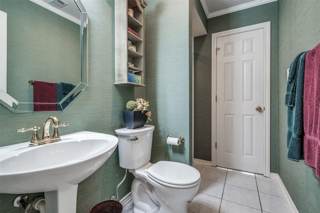 bathroom with crown molding, toilet, a sink, tile patterned flooring, and baseboards